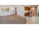 Spacious living room featuring neutral carpet, and an attached kitchen space with updated cabinetry and tile flooring at 13275 W Bolero Dr, Sun City West, AZ 85375