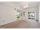 Open-concept living room featuring neutral carpet, light walls, and seamless access to the kitchen and outdoor patio at 13275 W Bolero Dr, Sun City West, AZ 85375