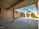 Spacious covered patio offering ample space for outdoor seating, featuring a serene view of palm trees and lush greenery at 13275 W Bolero Dr, Sun City West, AZ 85375