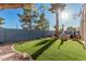 Bright backyard features synthetic grass, a palm tree and basketball hoop for entertaining at 1449 W Commerce Ave, Gilbert, AZ 85233