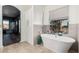 Elegant bathroom featuring a luxurious soaking tub, tiled walls, and natural light at 1449 W Commerce Ave, Gilbert, AZ 85233