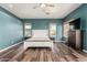Spacious bedroom featuring laminate floors, teal accent wall, and large windows with plenty of natural light at 1449 W Commerce Ave, Gilbert, AZ 85233