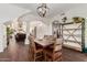 Open dining room with wood floors, rustic table, modern light fixture, and view of living room at 1449 W Commerce Ave, Gilbert, AZ 85233