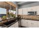 Close up on kitchen sink with garden window, granite countertops, and modern stainless appliances at 1449 W Commerce Ave, Gilbert, AZ 85233