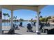 Covered dock with chairs overlooking a tranquil lake surrounded by palm trees and lakeside homes at 1449 W Commerce Ave, Gilbert, AZ 85233