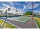 Community basketball court bordered with palm trees and green foliage on a sunny day with puffy white clouds at 1942 S Emerson -- # 127, Mesa, AZ 85210
