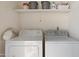 Bright laundry area featuring a washer, a dryer, and shelving for storage of laundry products and other household items at 1942 S Emerson -- # 127, Mesa, AZ 85210