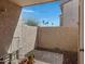 Enclosed patio with textured walls, stone flooring, gravel, potted plants, and partial views of the outside greenery at 1942 S Emerson -- # 127, Mesa, AZ 85210
