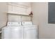 Convenient laundry area featuring a full-size white washer and dryer with overhead shelving at 2024 S Baldwin St # 161, Mesa, AZ 85209