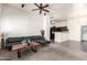 Open-concept living area with a modern sofa, ceiling fan, and bright lighting at 2024 S Baldwin St # 161, Mesa, AZ 85209