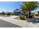 Inviting single-story home with a two-car garage, desert landscaping, and mature shade tree at 2116 S 238Th Ln, Buckeye, AZ 85326