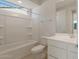 Clean bathroom featuring white fixtures, a shower-tub combo, and a large framed mirror at 21281 N 270Th Dr, Buckeye, AZ 85396