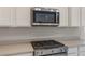 Kitchen detail with a stainless steel range and built-in microwave above the countertop at 21281 N 270Th Dr, Buckeye, AZ 85396