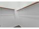 Walk-in closet with white walls and wood closet rods at 2483 E Narrowleaf Dr, Gilbert, AZ 85298