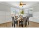 Elegant dining room featuring a wood table, six upholstered chairs, wainscoting, and shuttered windows at 2483 E Narrowleaf Dr, Gilbert, AZ 85298
