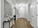 Long hallway with hardwood floors, console table with decor and a white front door at the end at 2483 E Narrowleaf Dr, Gilbert, AZ 85298