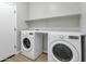 Laundry room featuring a front-load washer, dryer and shelving at 2483 E Narrowleaf Dr, Gilbert, AZ 85298