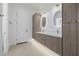 Modern bathroom featuring dual sinks with round mirrors and wood-grain cabinets at 2642 N Fiesta St, Scottsdale, AZ 85257