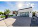 Modern home featuring a glass garage door, desert landscaping and concrete driveway at 2642 N Fiesta St, Scottsdale, AZ 85257