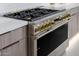 Close-up of a professional-grade stove with sleek design and gold knobs at 2642 N Fiesta St, Scottsdale, AZ 85257