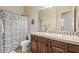 Well-lit bathroom featuring a vanity with decorative tile and a shower with patterned curtain at 32215 N 16Th Ave, Phoenix, AZ 85085