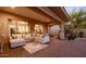 Relaxing covered patio featuring an oversized sofa, tile flooring, and decorative pillows at 32215 N 16Th Ave, Phoenix, AZ 85085