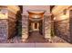 Inviting entrance with stone pillars, elegant lighting, and a decorative iron gate at 32215 N 16Th Ave, Phoenix, AZ 85085