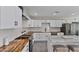 Modern kitchen featuring sleek white cabinetry, butcher block countertops, and stainless steel appliances at 3516 E Earll Dr, Phoenix, AZ 85018
