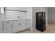 Kitchenette featuring white cabinets, a black retro-style refrigerator, and wood-look floors at 3516 E Earll Dr, Phoenix, AZ 85018