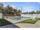 Sparkling pool with artificial turf, a white fence, trees and a decorative chair at 3516 E Earll Dr, Phoenix, AZ 85018
