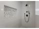 Stylish shower with white subway tile and unique pebble accent wall at 3516 E Earll Dr, Phoenix, AZ 85018