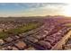 Scenic aerial view of a well-planned community, golf course, and mountain views at sunset at 37148 N Stoneware Dr, Queen Creek, AZ 85140