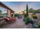 Relaxing backyard features lounge chairs, outdoor dining, built-in grill, lush landscaping and water feature at 37148 N Stoneware Dr, Queen Creek, AZ 85140