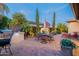 Expansive backyard patio features a grill, dining set, and lounge chair with lush landscaping at 37148 N Stoneware Dr, Queen Creek, AZ 85140