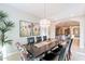Elegant dining room with a statement chandelier, decorative wall art and an open view to the kitchen at 37148 N Stoneware Dr, Queen Creek, AZ 85140