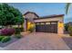 View of the home's exterior showcases a two-car garage and beautiful stone and desert landscaping at 37148 N Stoneware Dr, Queen Creek, AZ 85140