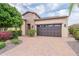 Beautiful single-Gathering home with stone accents, neutral stucco, and brick driveway at 37148 N Stoneware Dr, Queen Creek, AZ 85140