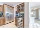 Kitchen featuring stainless steel refrigerator, glass front cabinets, wine cooler, granite countertop, and tile flooring at 37148 N Stoneware Dr, Queen Creek, AZ 85140