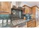 Gourmet kitchen with stainless steel appliances, granite countertops, gas range, and custom wood cabinetry at 37148 N Stoneware Dr, Queen Creek, AZ 85140