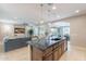 Open floor plan featuring a spacious living room, kitchen with an island, and dining area with ample natural light at 37148 N Stoneware Dr, Queen Creek, AZ 85140