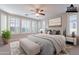 Bright main bedroom with plantation shutters, a ceiling fan, and neutral décor exudes comfort and style at 37148 N Stoneware Dr, Queen Creek, AZ 85140