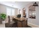 Stylishly staged office with arched doorways, shutters, hardwood desk and view into the living area at 37148 N Stoneware Dr, Queen Creek, AZ 85140
