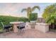 Outdoor kitchen features a built-in grill, bar seating, and lush landscaping at 37148 N Stoneware Dr, Queen Creek, AZ 85140