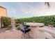 Outdoor kitchen features a built-in grill, bar seating, and lush landscaping at 37148 N Stoneware Dr, Queen Creek, AZ 85140