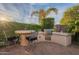 Beautiful outdoor kitchen with grill, bar, and seating area, perfect for entertaining under the Arizona sky at 37148 N Stoneware Dr, Queen Creek, AZ 85140