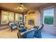 Inviting outdoor living space features a fireplace, ceiling fan, and comfortable seating at 37148 N Stoneware Dr, Queen Creek, AZ 85140