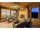 Cozy covered patio with fireplace, ceiling fan, and comfortable seating, perfect for relaxing evenings at 37148 N Stoneware Dr, Queen Creek, AZ 85140