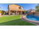 Expansive backyard featuring a shimmering pool, covered patio, well-manicured lawn, and outdoor basketball for active enjoyment at 3848 S Coach House Dr, Gilbert, AZ 85297