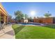 Great backyard with a sparkling swimming pool, artificial turf, and covered patio for Gathering fun and outdoor relaxation at 3848 S Coach House Dr, Gilbert, AZ 85297