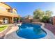Spacious backyard with a sparkling pool, covered patio, and lush landscaping for serene outdoor enjoyment and entertainment at 3848 S Coach House Dr, Gilbert, AZ 85297